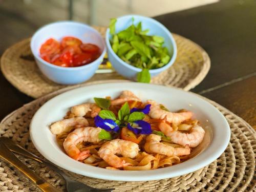a plate of shrimp and vegetables on a table at Pousada Taipa dos Milagres in São Miguel dos Milagres