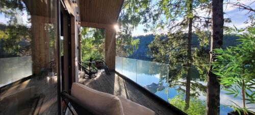 a room with a balcony with a view of a lake at Moderne hytte i vannkanten med tilgang til brygge og båt in Risør