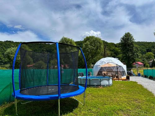 a blue trampoline in the grass next to a tent at Hideaway Glamping in Banská Bystrica