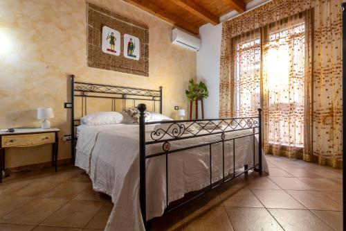 a bedroom with a bed and a large window at Tri Re e 'na Regina in Cinisi
