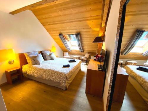 a bedroom with a bed and two windows at Auberge de l'Union in Arzier