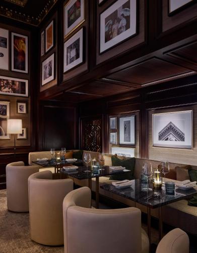 a restaurant with tables and chairs and pictures on the wall at Rosewood Hotel Georgia in Vancouver