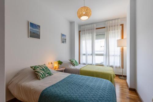 a room with two beds and a window at Piso A Pie de Playa - A Corna in San Pedro