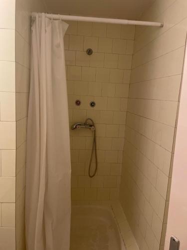 a bathroom with a shower with a white shower curtain at Tifani Szálló in Balatonlelle