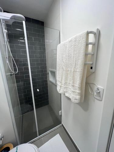 a bathroom with a shower and a toilet and a towel at Innvista Nex One Itaim in Sao Paulo