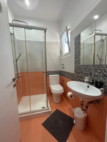 a bathroom with a shower and a sink and a toilet at KavirosHome in Pefki