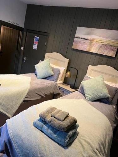 a hospital room with two beds with towels on them at The Crown Inn in Gayton