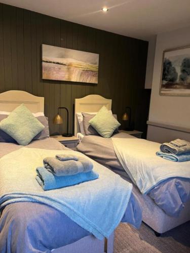 a bedroom with two beds with towels on them at The Crown Inn in Gayton