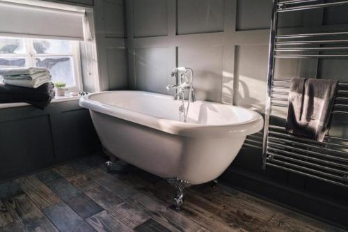 a white bath tub in a bathroom with a window at The Crown Inn in Gayton