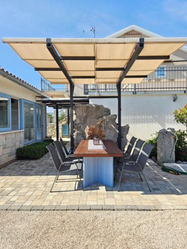 a table and chairs under an umbrella on a patio at Villa Dora in Bajčići