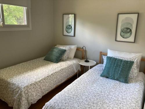 a bedroom with two beds and a table with a lamp at Direct Lakefront cottage on Lake Simcoe in Orillia in Orillia