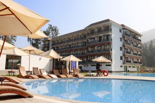hotel z basenem z krzesłami i parasolami w obiekcie Ribera del Rio Club Resort w mieście Cieneguilla