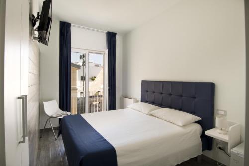 una camera con un grande letto e una finestra di Locanda degli Angioini Locazione Turistica a Mola di Bari