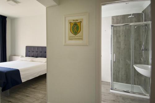 a bedroom with a bed and a bathroom with a sink at Locanda degli Angioini Locazione Turistica in Mola di Bari