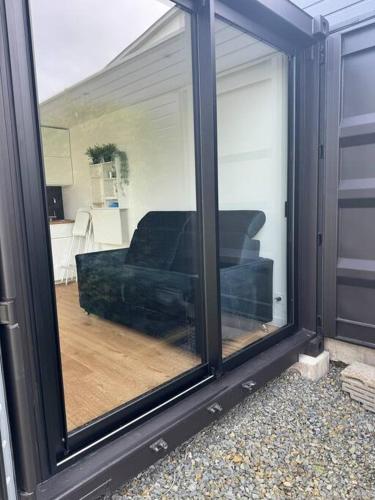 Elle offre une vue sur un salon doté d'un canapé et d'une fenêtre. dans l'établissement Conteneur studio, à Saint-Père