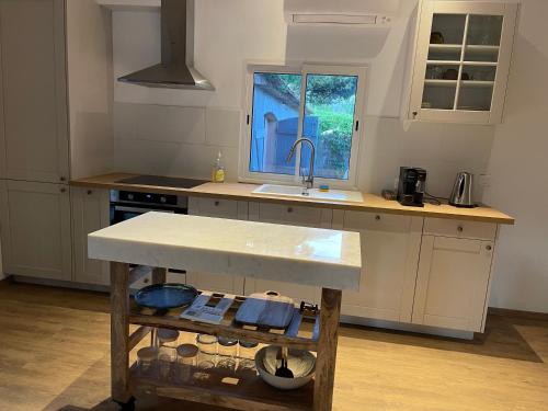 une cuisine avec un comptoir, un évier et une fenêtre dans l'établissement Maison de Charme au Milieu des Vignes avec Jardin et Parking à Gassin, près de Saint-Tropez, à Gassin