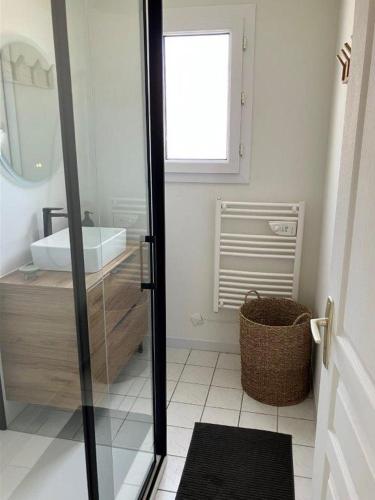 une salle de bain avec un lavabo et un miroir dans l'établissement Maison Dunes des Huttes, à Saint-Denis-dʼOléron