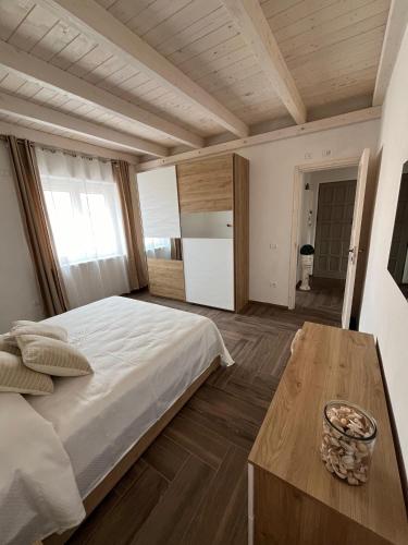 Un dormitorio con una cama grande y una mesa de madera. en Casa vacanze Iris, en Carbonia