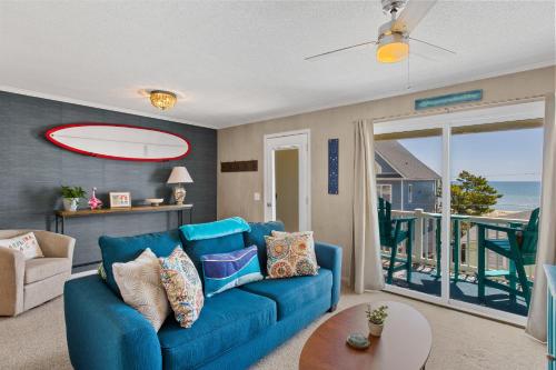 a blue couch in a living room with a view of the ocean at Tropical Winds - Ferda Buoys in Carolina Beach