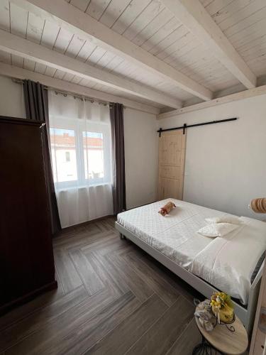 Un dormitorio con una cama y una ventana grande. en Casa vacanze Iris, en Carbonia