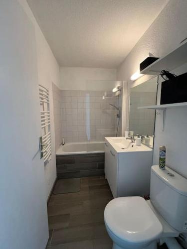 une salle de bain avec toilettes, lavabo et baignoire dans l'établissement Charmant studio rénové, à Hourtin