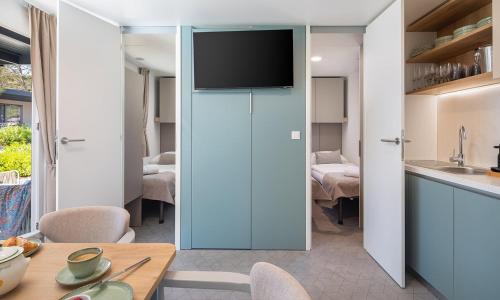 a kitchen with a sliding glass door with a television on it at Aminess Style Glamping Villas & Holiday Homes Avalona in Povljana