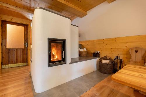 a fireplace in a room with a wooden wall at Chatka v lese in Ružomberok