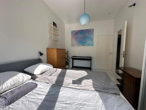a bedroom with a large bed and a desk at Kodikas ja supermukava asunto metron vieressä! Smart TV, nopea netti, 5 minuuttia keskustaan! in Helsinki