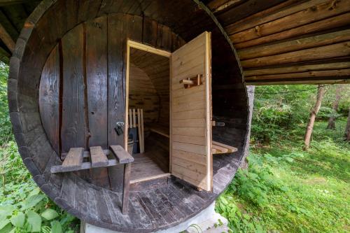 a large wooden outhouse with a bench in the middle at Chatka v lese in Ružomberok