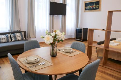 a living room with a table with a vase of flowers at Cluj Downtown Accomodation in Cluj-Napoca