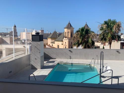 a swimming pool on the roof of a building at Livemálaga Alta Suite & Parking in Málaga