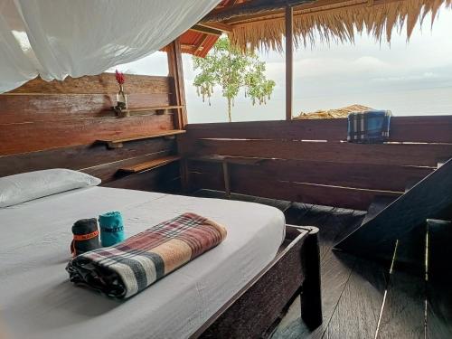 a bed in a boat with a towel on it at Lodge El Amargal - Reserva Natural, Ecoturismo & Surf in Nuquí
