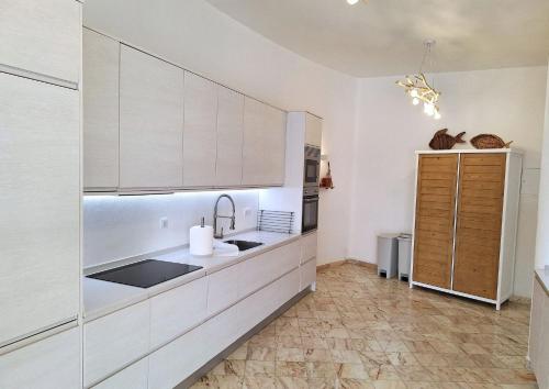 a kitchen with white cabinets and a sink at Casa Oceanis in Salema