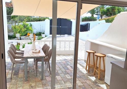 a table with chairs and an umbrella on a patio at Casa Oceanis in Salema