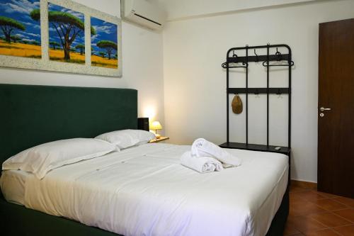 Un dormitorio con una cama grande con sábanas blancas. en Il Giardino di Morris, en Giardini Naxos