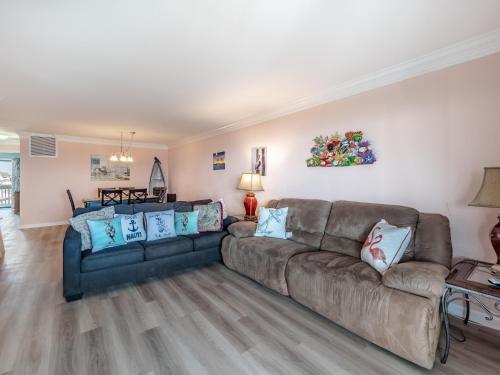 a living room with a brown couch and blue pillows at Winds V1 #2B - My Paradise in Carolina Beach