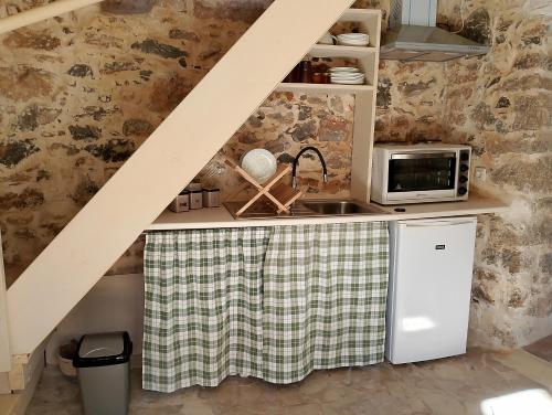 a small kitchen with a sink and a microwave at Agrotourism Traditional Houses in Apóstoloi