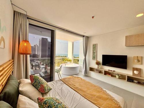 une chambre avec une grande fenêtre avec une baignoire et une télévision dans l'établissement Loft vista mar terraza jacuzzi, à Santa Marta