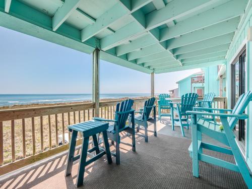 a row of tables and chairs on a balcony with the beach at Winds V1 #2B - My Paradise in Carolina Beach