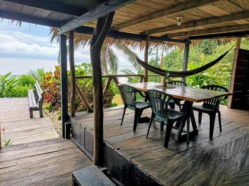 a wooden deck with a table and chairs on it at Lodge El Amargal - Reserva Natural, Ecoturismo & Surf in Nuquí