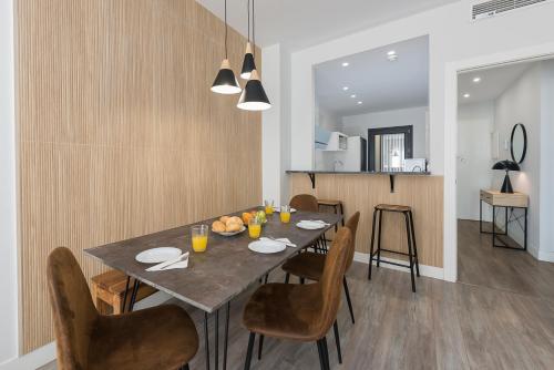 a dining room with a table and chairs at Livemálaga Alta Suite & Parking in Málaga