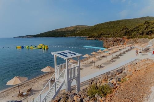 a beach with a bunch of umbrellas and the water at LUSTICA BAY GARDEN APARTMENT, Centrale in Tivat