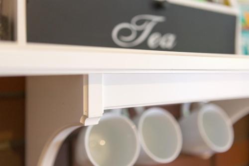 a row of white coffee cups on a shelf at Villa Jeziorki 71 in Warsaw