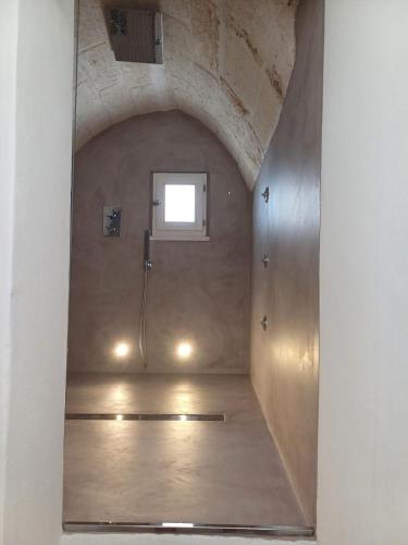 an empty room with a window in a brick wall at Casamareluna in Ostuni