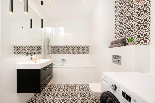 a white bathroom with a sink and a toilet at Manufaktura Residence - Apartamenty Industrial z Parkingiem i Dwoma Łazienkami in Łódź