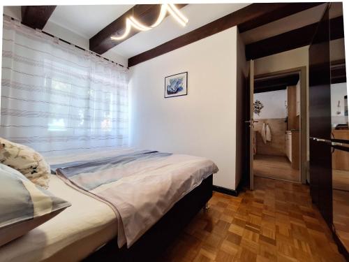 a bedroom with a large bed and a window at Apartment EMMA in Povile