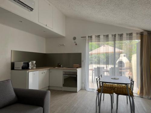 un salon avec une table et une cuisine dans l'établissement Bord de mer avec piscine Type 2, à Santa-Maria-Poggio