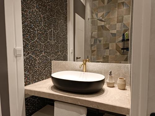 a bathroom with a black and white sink on a counter at Apartman Verde free parking in Sarajevo
