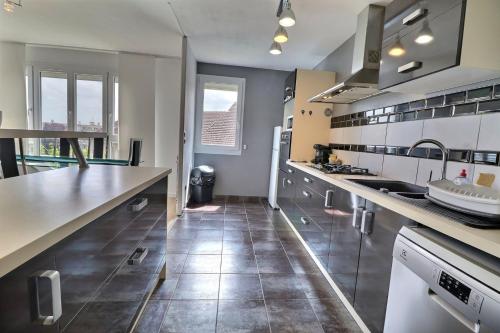 Il comprend une cuisine équipée d'appareils en acier inoxydable et du carrelage. dans l'établissement Le Factory - Grand & Lumineux - Mon Groom, à Troyes