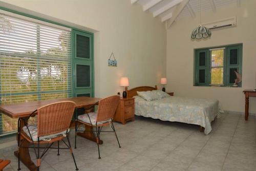 a bedroom with a bed and a table and chairs at Kas Berde Kanti Laman in Kralendijk